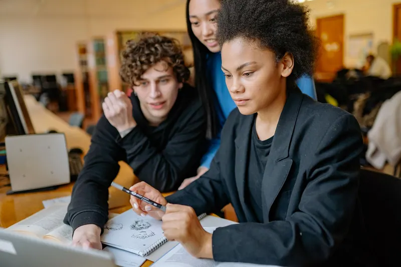 Studierende arbeiten gemeinsam am Laptop